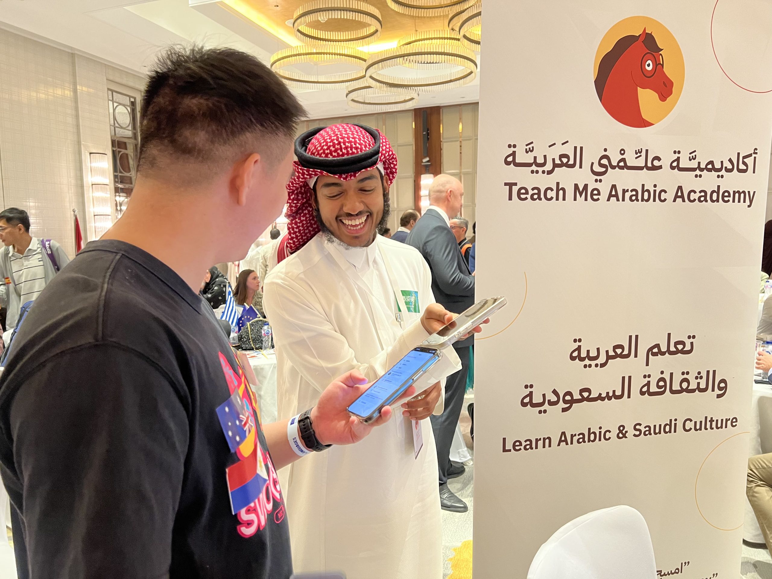 أحد موظفي ياهلا يتفاعل مع زوار فعالية الليلة الأوروبية 2025 للتعريف باللغة العربية والثقافة السعودية
